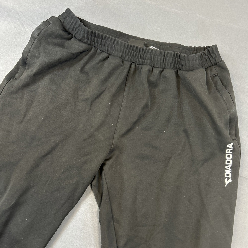 black Diadora track pants feature a‎ white logo Medium